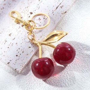 Golden cherry shaped keychain made of red and gold colored resin NWT